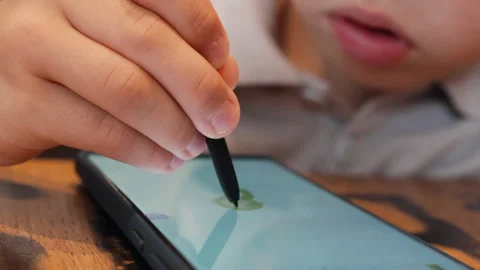 Boy creates vibrant drawings with a stylus on smartphone. Stock Footage 287987729