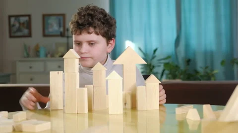 Boy creatively builds a building out of bricks. Board educational game. Video stock 150244650