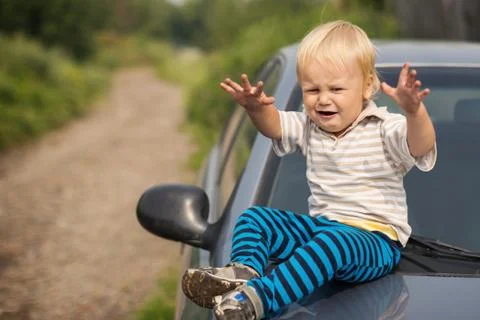 Boy cries by the car Foto stock