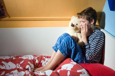 Boy crying on his bed Stock Photos