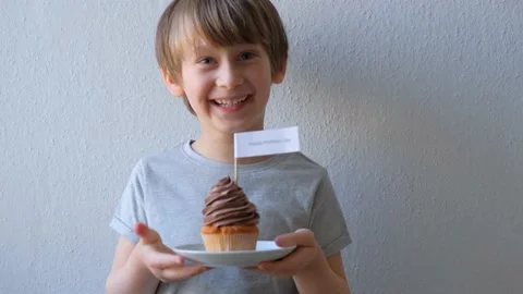 Boy with a cupcake in his hands congratulates mom Stock Footage 152840468