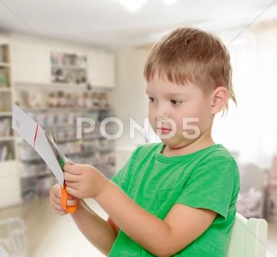 Boy cuts with scissors cardboard Stock Photos