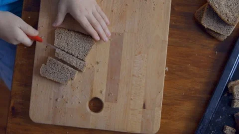 Boy is cutting bread on wooden board Stock Footage 102544082