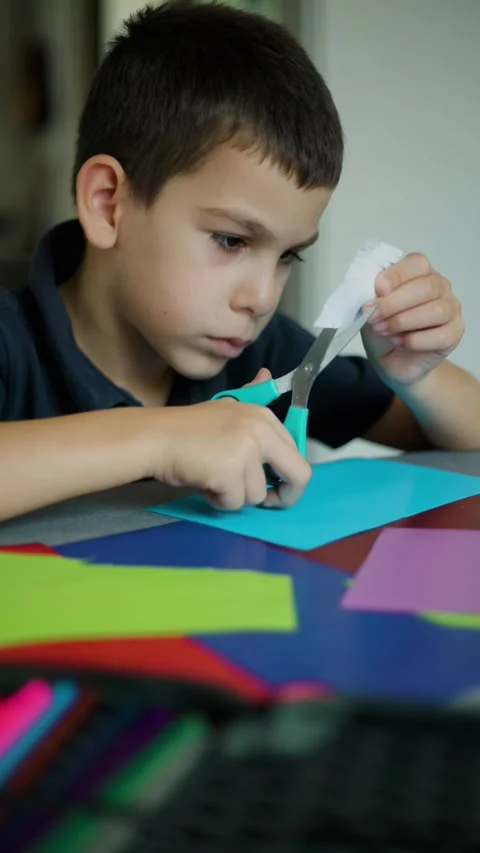 Boy Cutting Green Paper With Scissors Vertical Video Slow Motion Video stock 343451555