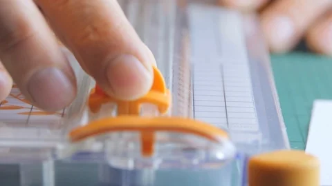 Boy cutting a sheet of paper in two with the paper trimmer Video stock 123355757
