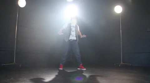 A boy dances by widening his hands with background lights Stockbeeldmateriaal 22819384