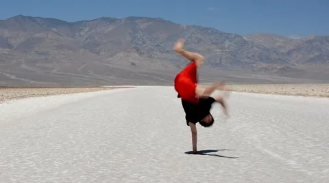 Boy dancing breakdance in the famous Death Valley USA Stock Footage 40416878