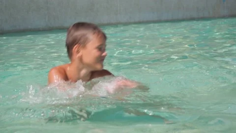 A boy is dancing in an outdoor pool. have fun. relax in the outdoor pool Stock Footage 165989285