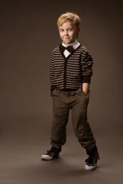 Boy dancing over brown background. Vintage style kids fashion Stock Photos