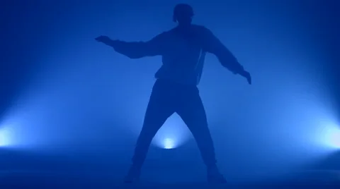 Boy dancing in a smoke on a blue background Stock Footage 63082679