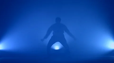 Boy dancing in a smoke on a blue background Stock Footage 63083005