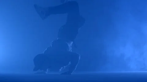 Boy dancing in a smoke on a blue background Stock Footage 63083015