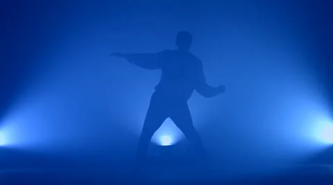 Boy dancing in a smoke on a blue background Stock Footage 63083199