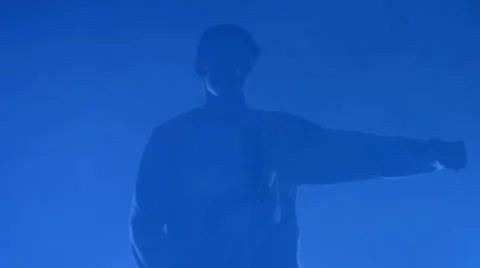 Boy dancing in a smoke on a blue background Stock Footage 63083289