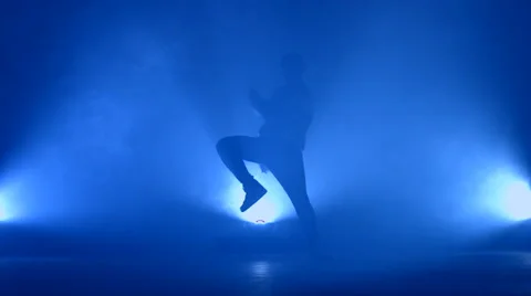 Boy dancing in a smoke on a blue background Stock Footage 63083335