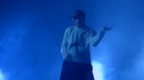 Boy dancing in a smoke on a blue background Stock Footage 63083390