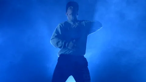 Boy dancing in a smoke on a blue background Stock Footage 63083921