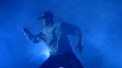 Boy dancing in a smoke on a blue background Stock Footage 63084249