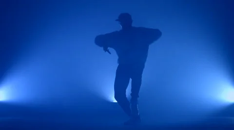 Boy dancing in a smoke on a blue background Stock Footage 63084261