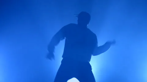 Boy dancing in a smoke on a blue background Stock Footage 63084288