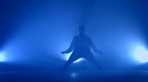 Boy dancing in a smoke on a blue background Stock Footage 63084732