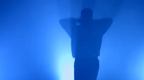 Boy dancing in a smoke on a blue background Stock Footage 63084791