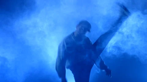 Boy dancing in a smoke on a blue background Stock Footage 63084796