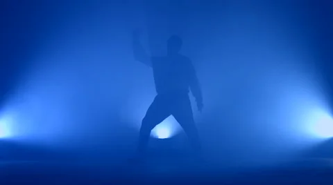 Boy dancing in a smoke on a blue background Stock Footage 63084821