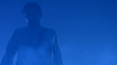 Boy dancing in a smoke on a blue background Stock Footage 63086433