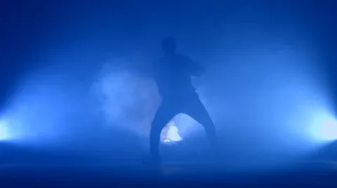 Boy dancing in a smoke on a blue background Stock Footage 63087084