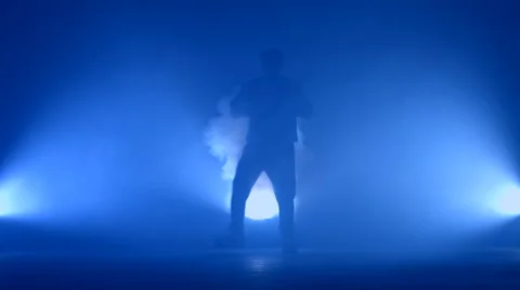 Boy dancing in a smoke on a blue background Stock Footage 63087391