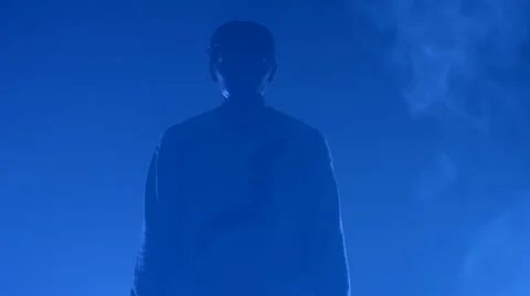 Boy dancing in a smoke on a blue background Stock Footage 63087784