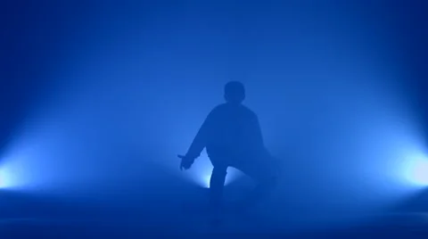 Boy dancing in a smoke on a blue background Stock Footage 63088105