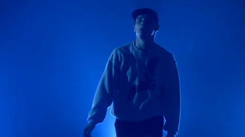 Boy dancing in a smoke on a blue background Stock Footage 63088407