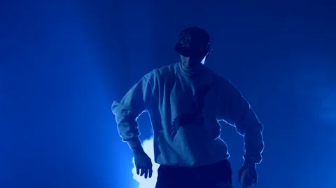 Boy dancing in a smoke on a blue background Stock Footage 63088584