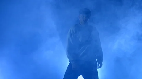 Boy dancing in a smoke on a blue background Stock Footage 63088726