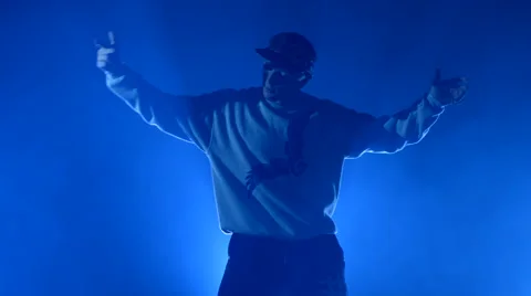 Boy dancing in a smoke on a blue background Stock Footage 63088734