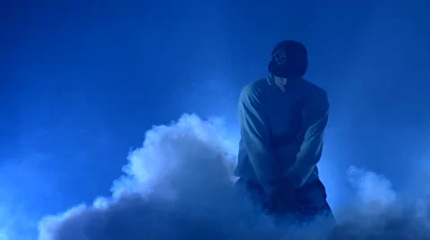 Boy dancing in a smoke on a blue background Stock Footage 63088915