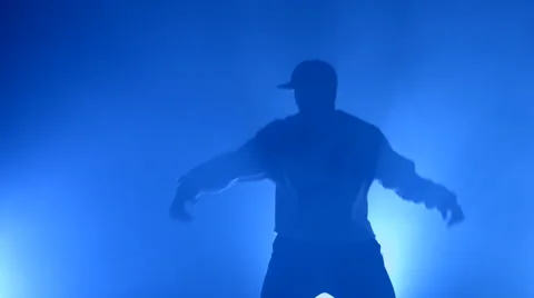 Boy dancing in a smoke on a blue background Stock Footage 63089232