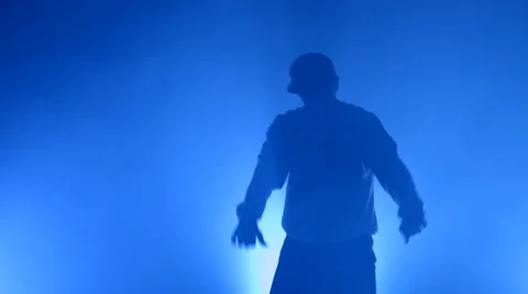 Boy dancing in a smoke on a blue background Stock Footage 63089441