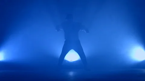 Boy dancing in a smoke on a blue background Stock Footage 63089489