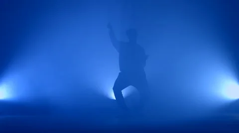 Boy dancing in a smoke on a blue background Stock Footage 63090067