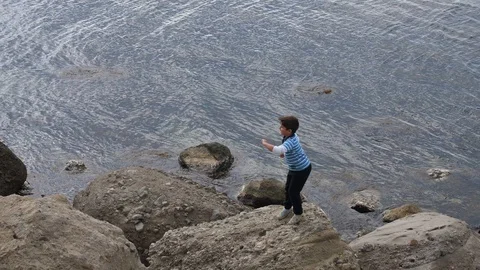 Boy dancing on a stone by the sea Stock-Footage 97111515