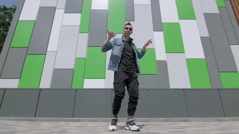 Boy dancing street modern dance on an open stage in public park. Slow motion Stock Footage 132659937