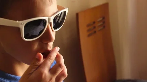 Boy in dark glasses eating candy Stock Footage 65300405