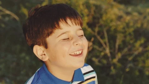 A boy with dark hair laughs all over his mouth Stock Footage