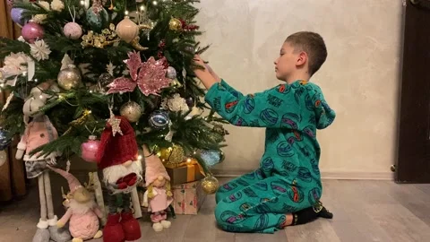 The boy decorates christmas tree at home Stock Footage 167202144