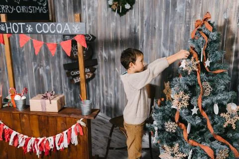 Boy decorates Christmas tree Stock Photos