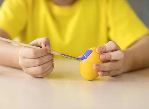 Boy decorates Easter egg, close-up Stock Photos