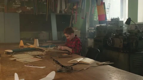 A boy decorates his airplane model with stickers 库存影片 171010526